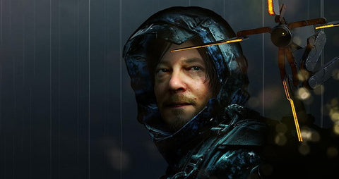 Person in futuristic hooded suit with glowing object against dark background